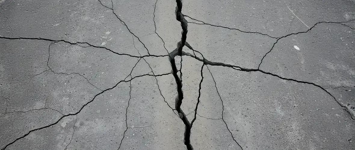 Concrete driveway with visible cracks showing the need for professional inspection and maintenance evaluation